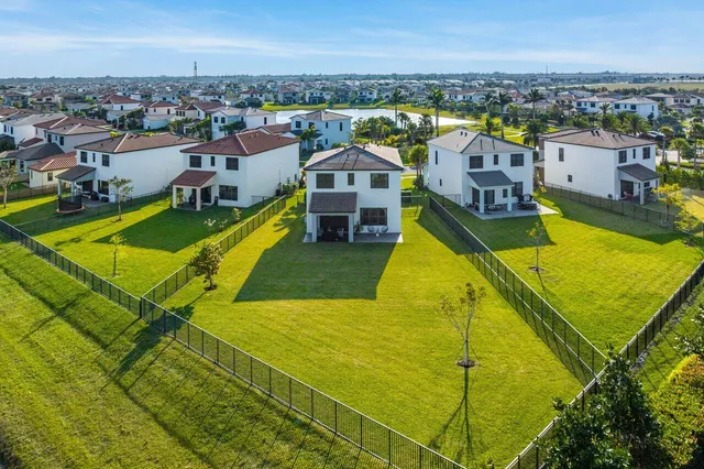 an aerial view of residential houses with outdoor space and swimming pool