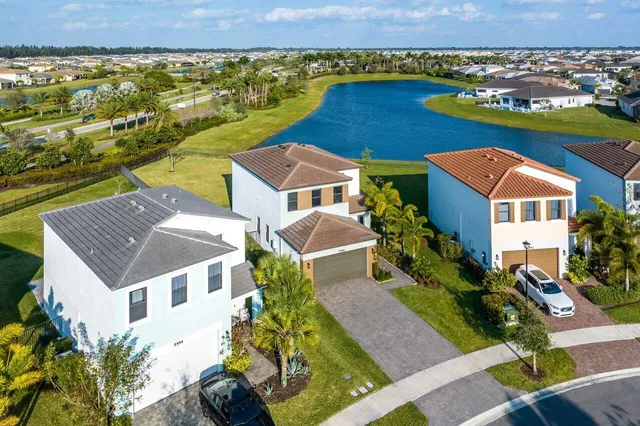 an aerial view of a house with a garden and lake view