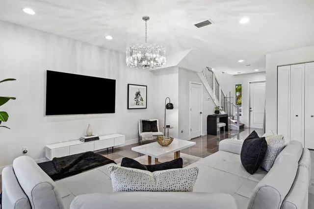 a living room with furniture a flat screen tv and kitchen view