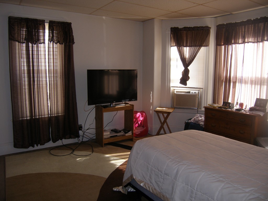 39-41 Gilman Street Somerville, MA 02145 - Photo 22 of 30 a bedroom with bed and large window