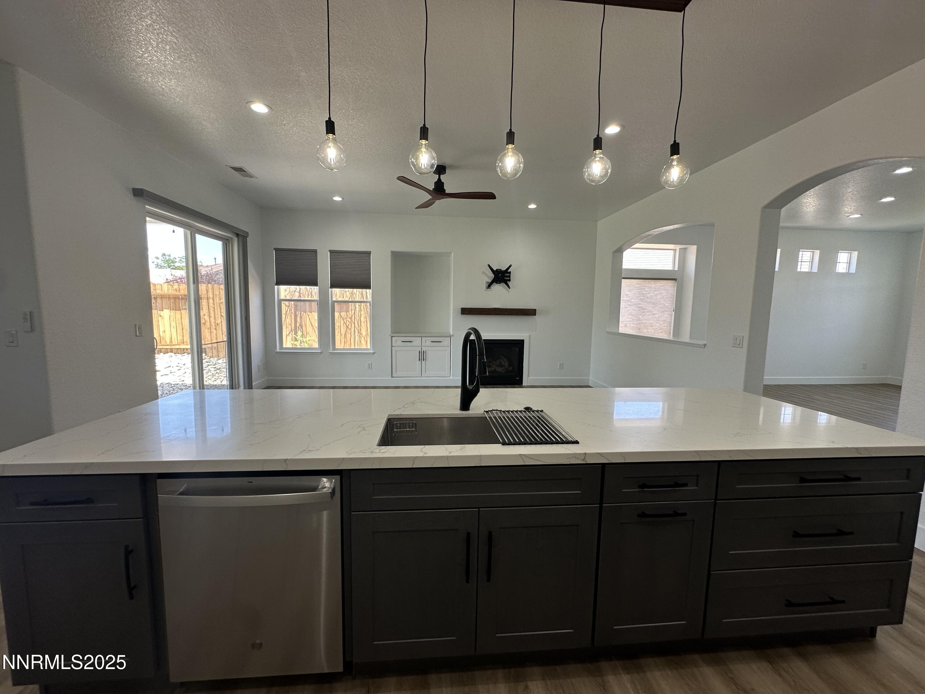 9533 Steep Climb Court Reno, NV 89521 - Photo 16 of 34 a kitchen with kitchen island granite countertop a sink a counter space appliances and cabinets