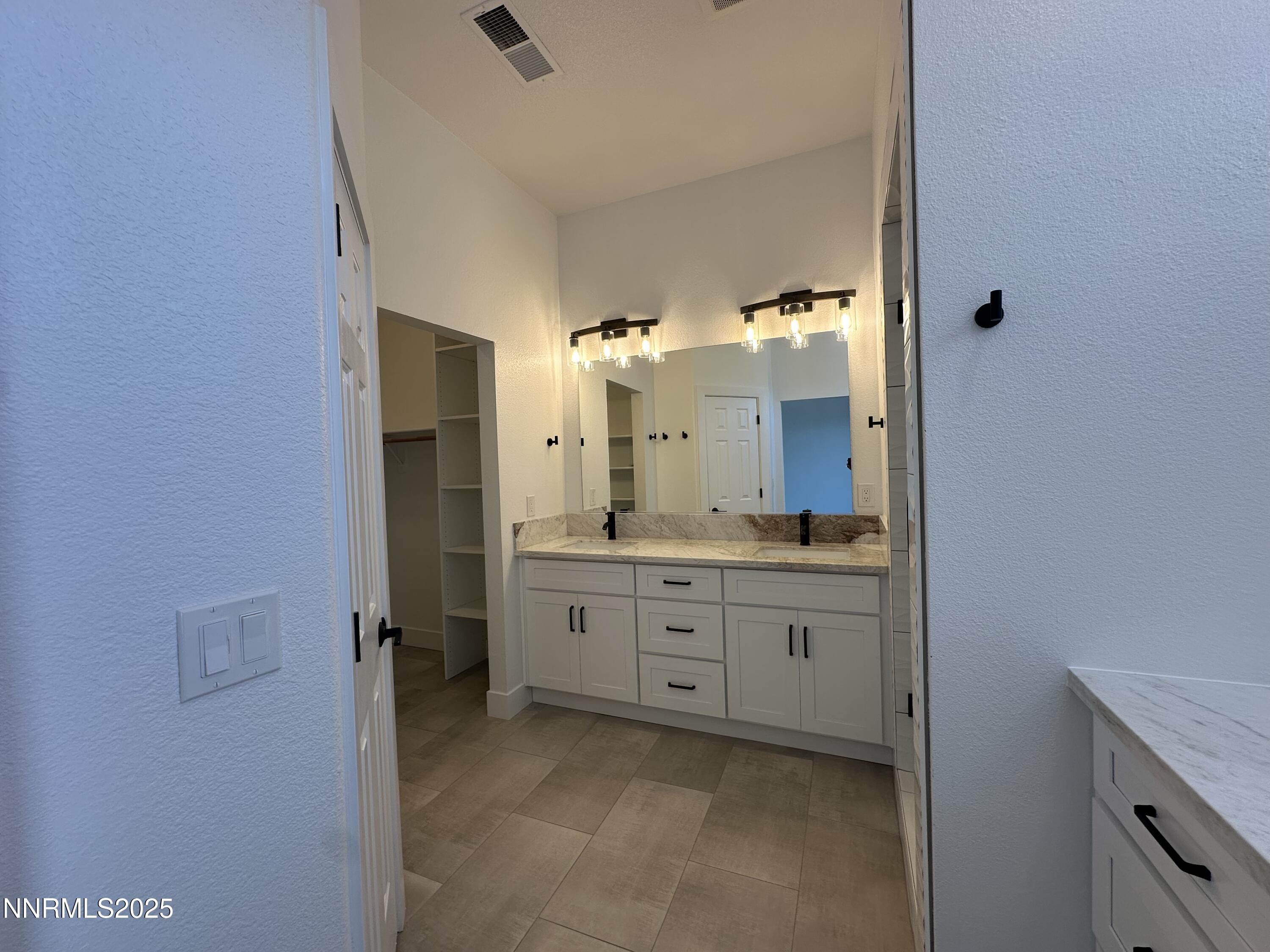 9533 Steep Climb Court Reno, NV 89521 - Photo 20 of 34 a spacious bathroom with a granite countertop sink mirror and a