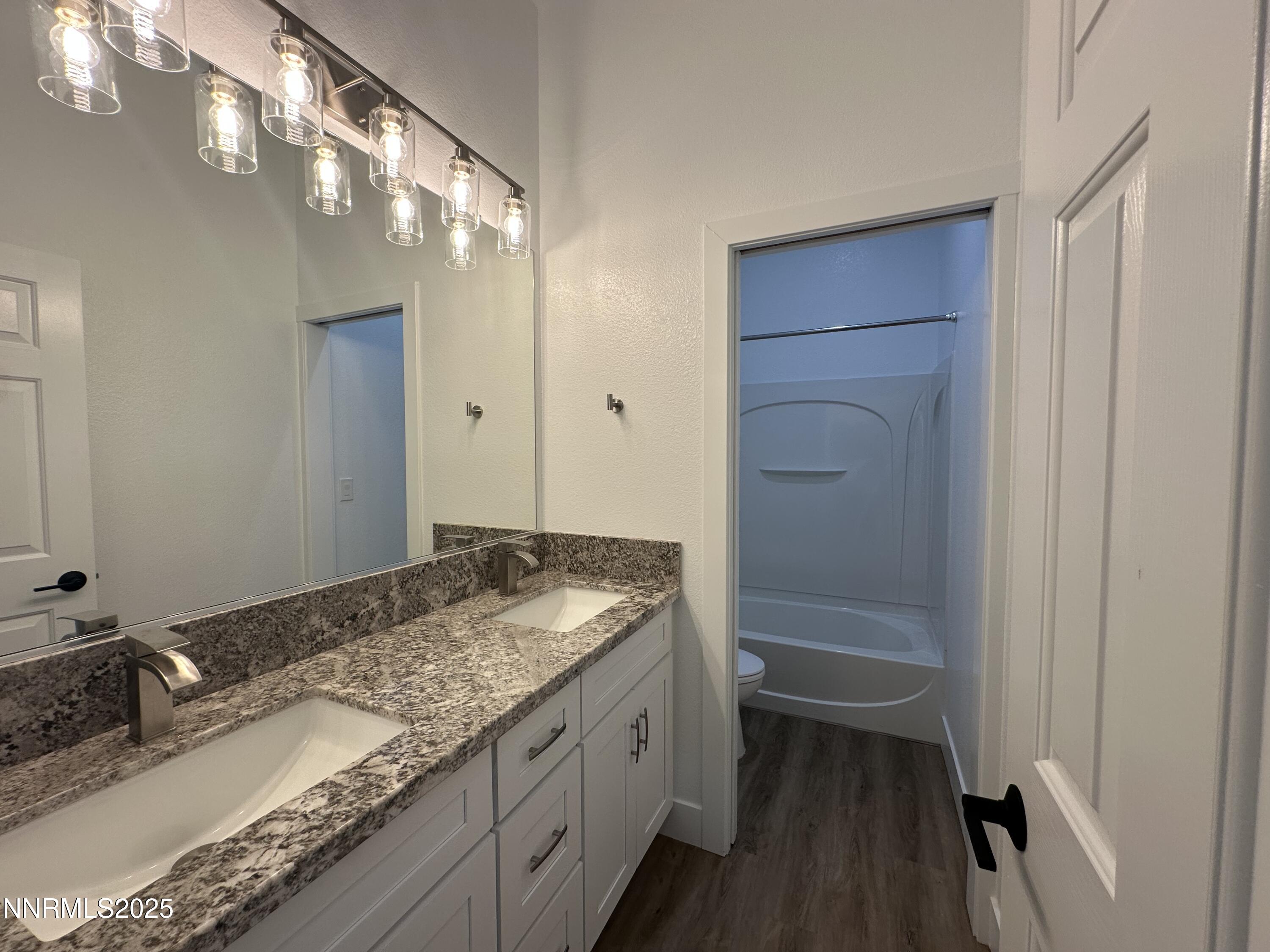 9533 Steep Climb Court Reno, NV 89521 - Photo 26 of 34 a bathroom with a granite countertop sink and a mirror