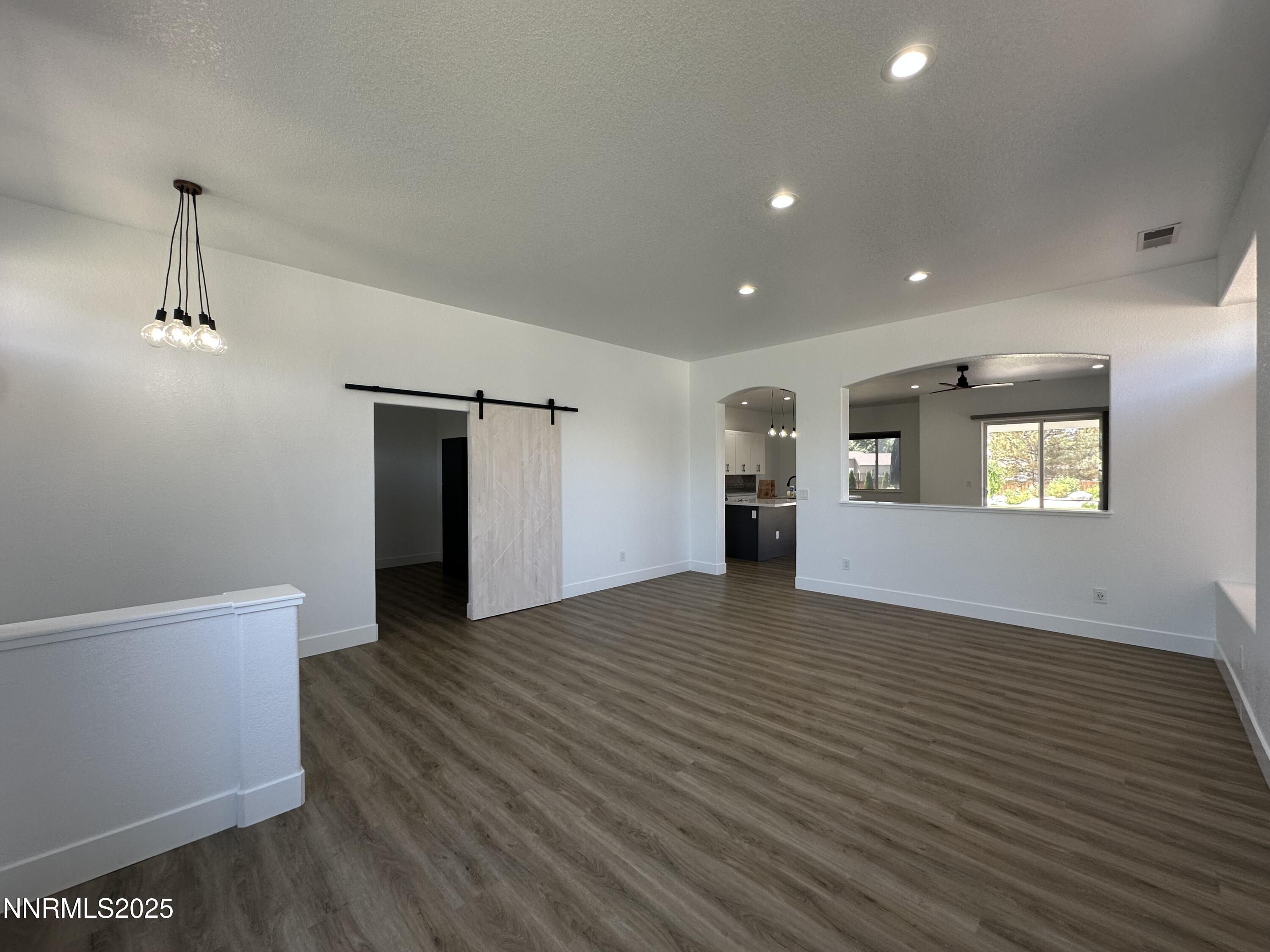 9533 Steep Climb Court Reno, NV 89521 - Photo 4 of 34 a view of an empty room with a window and wooden floor