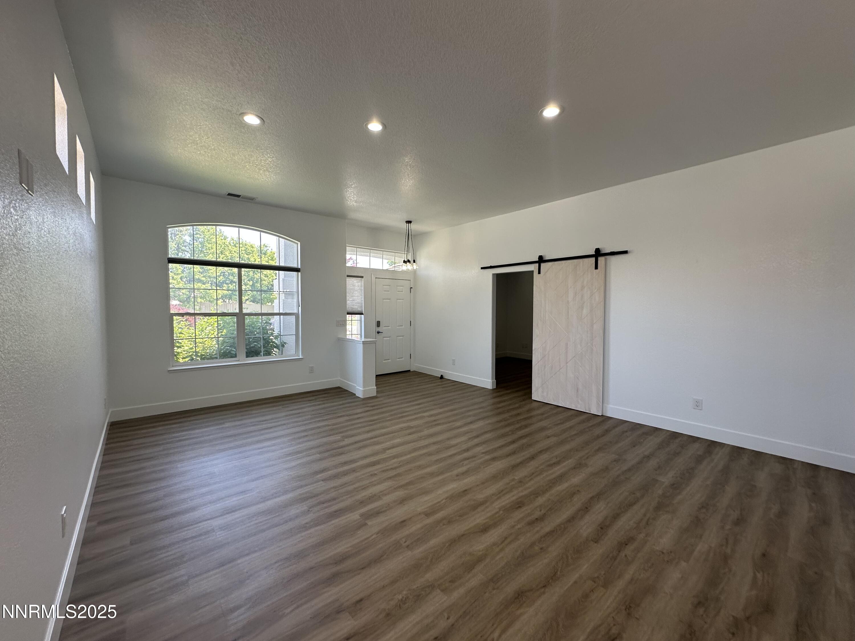 9533 Steep Climb Court Reno, NV 89521 - Photo 5 of 34 an empty room with wooden floor and windows