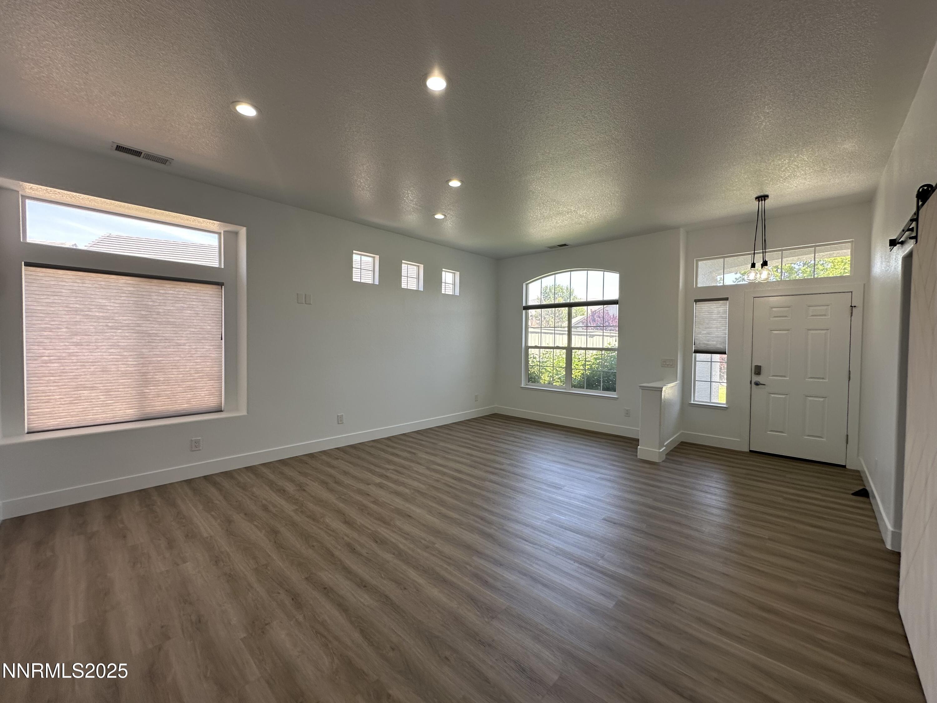 9533 Steep Climb Court Reno, NV 89521 - Photo 6 of 34 an empty room with wooden floor and windows