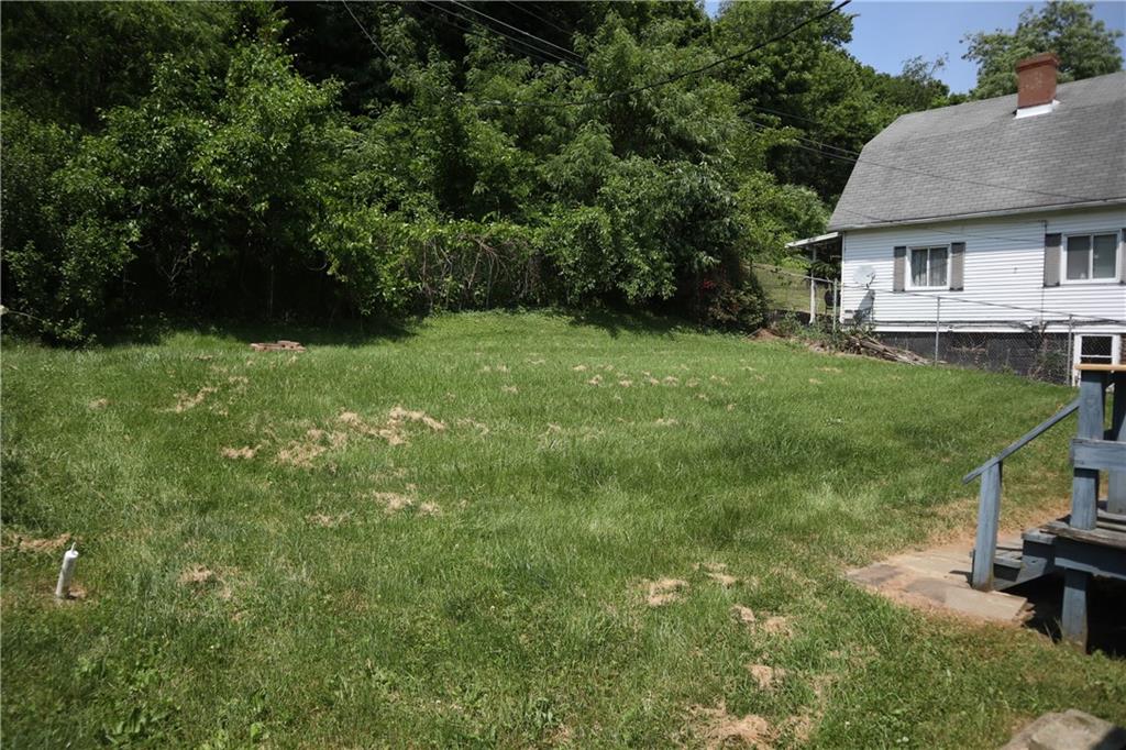 721 Spring Street Roscoe, PA 15477 - Photo 4 of 30 a view of a backyard with table and chairs with wooden fence