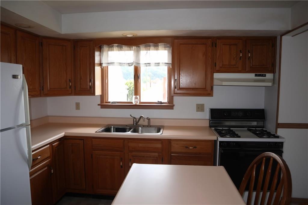 721 Spring Street Roscoe, PA 15477 - Photo 8 of 30 a kitchen with a sink a stove a microwave and refrigerator