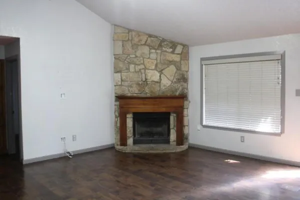 an empty room with a fireplace and windows