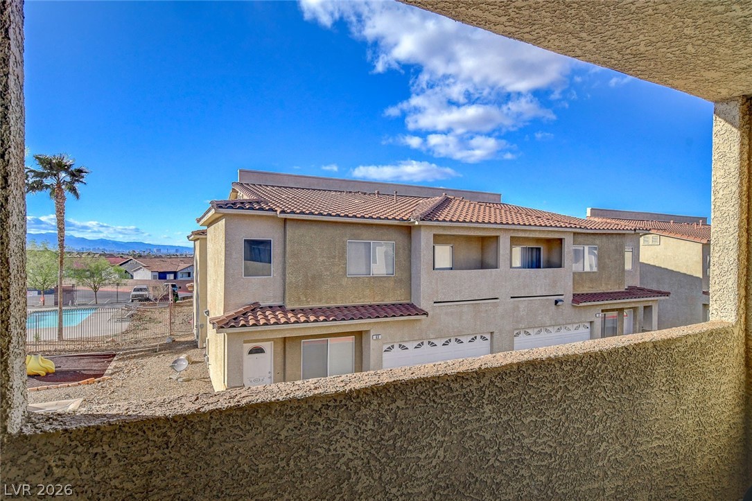 64 Brown Swallow Way Henderson, NV 89012 - Photo 25 of 42 Back of house featuring stucco siding, a tiled roof, a balcony, and a mountain view