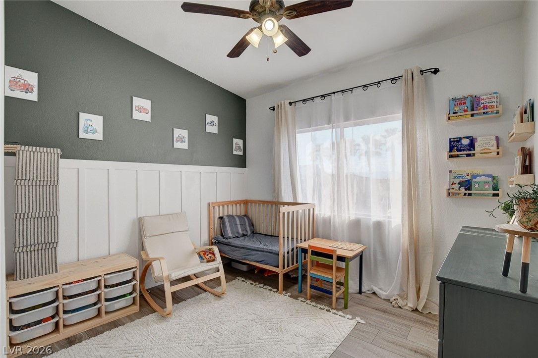 64 Brown Swallow Way Henderson, NV 89012 - Photo 29 of 42 Sitting room with ceiling fan, wainscoting, light wood-type flooring, and a decorative wall