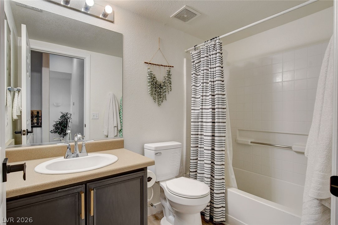 64 Brown Swallow Way Henderson, NV 89012 - Photo 31 of 42 Full bathroom featuring vanity, shower / bathtub combination with curtain, and a textured wall