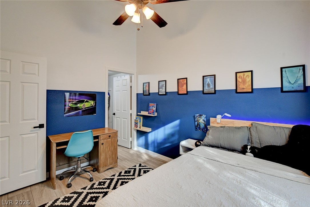 64 Brown Swallow Way Henderson, NV 89012 - Photo 34 of 42 Bedroom featuring light wood-style flooring, a desk, ceiling fan, and a high ceiling