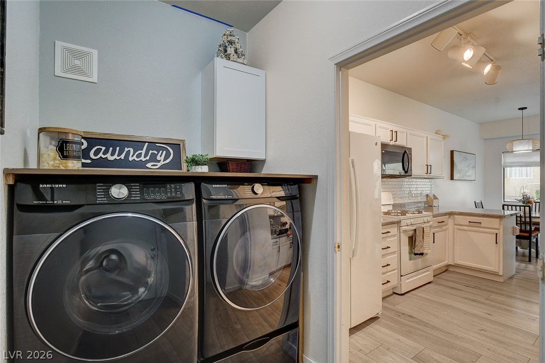 64 Brown Swallow Way Henderson, NV 89012 - Photo 35 of 42 Laundry room featuring light wood-style flooring, separate washer and dryer, and track lighting