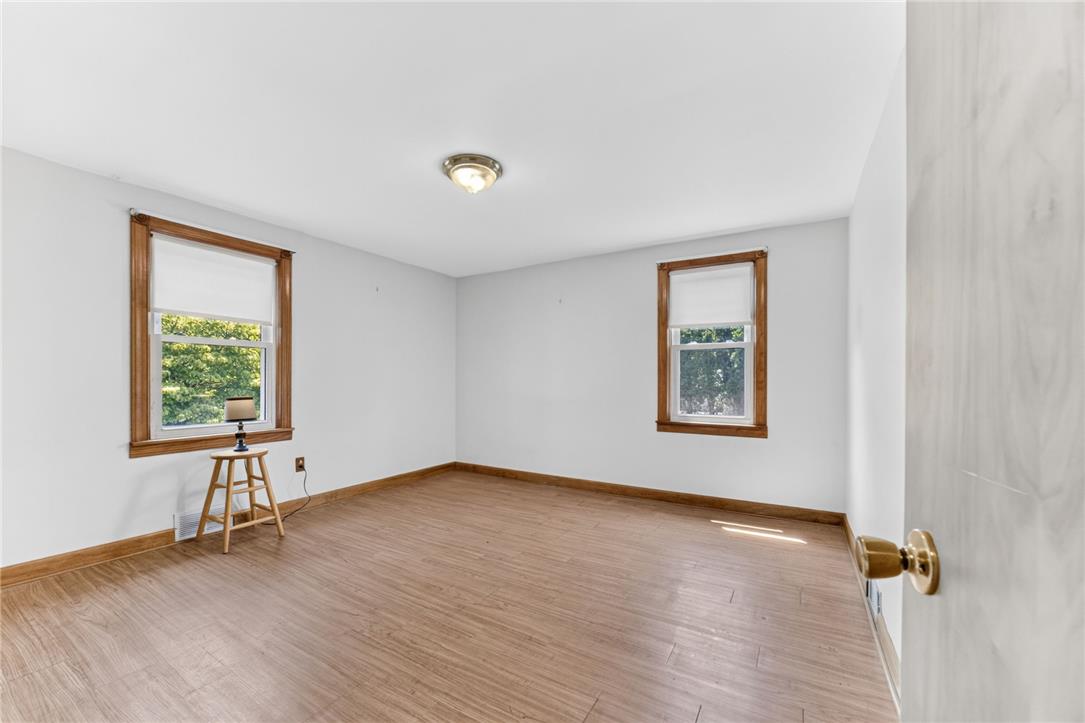 1166 Stones Crossing Road Easton, PA 18045 - Photo 6 of 35 Ample natural illumination fills this inviting bedroom, featuring rich hardwood-style flooring and detailed wooden trim.