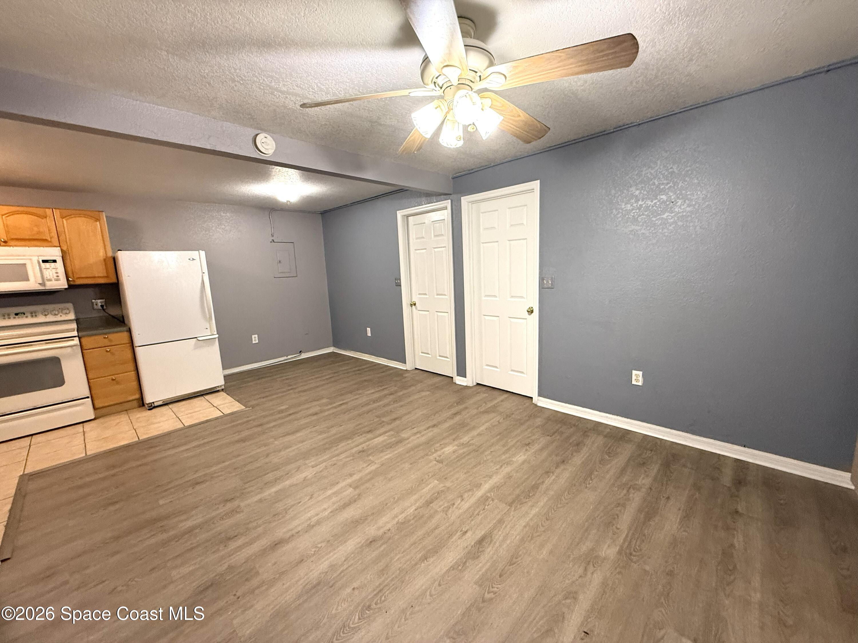 2127 Smathers Circle South, Unit B Melbourne, FL 32935 - Photo 3 of 32 wooden floor in an empty room with a window