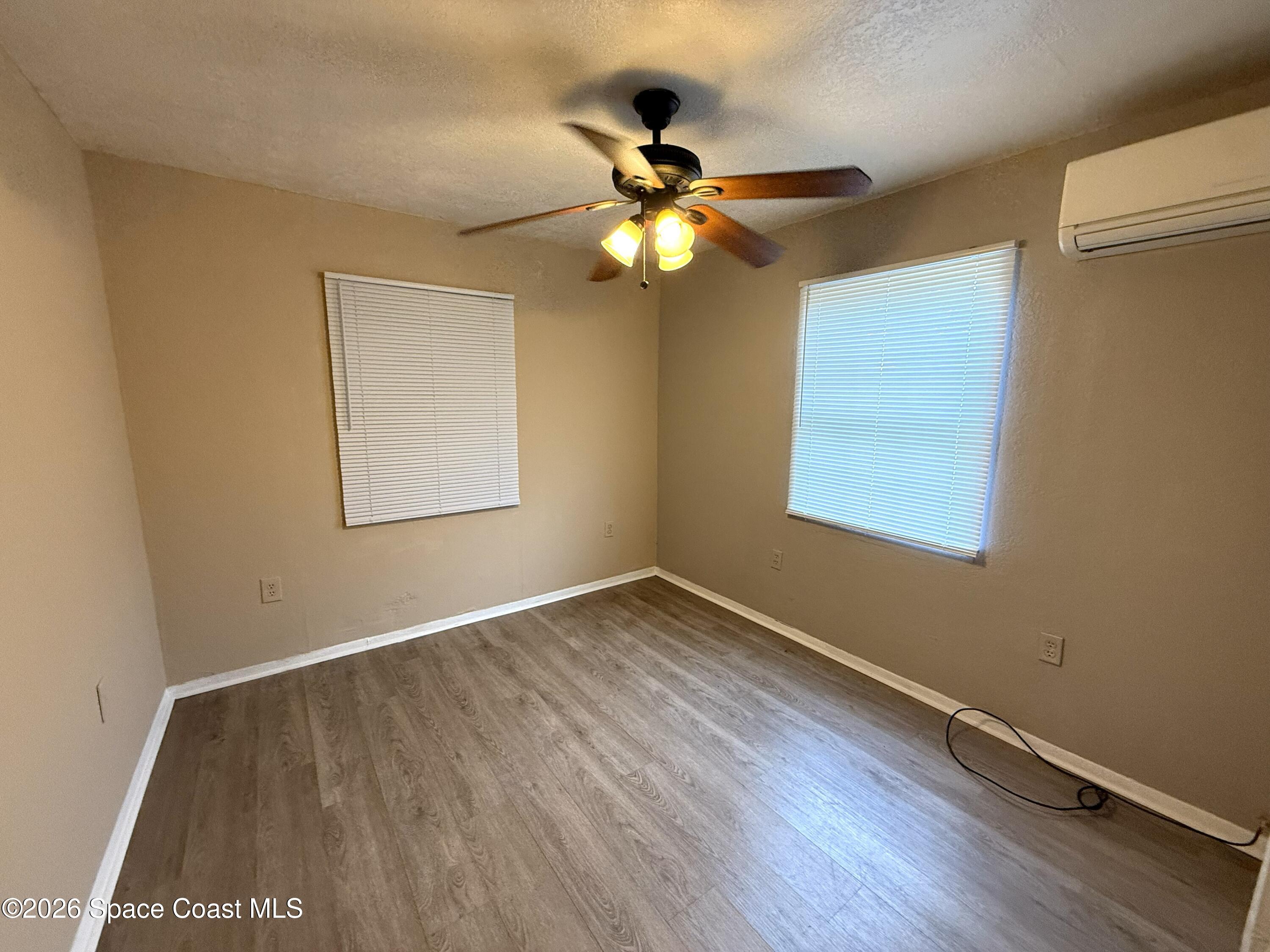2127 Smathers Circle South, Unit B Melbourne, FL 32935 - Photo 8 of 32 a view of an empty room with wooden floor and a window