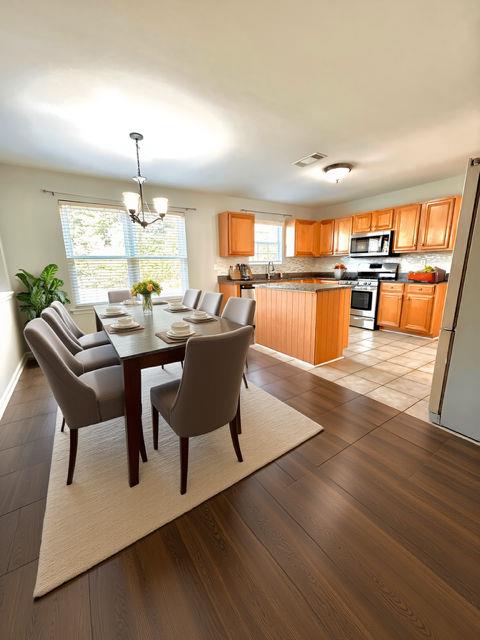 4350 Defoors Farm Trail Powder Springs, GA 30127 - Photo 11 of 47 a dining room with wooden floor a chandelier a glass table and chairs