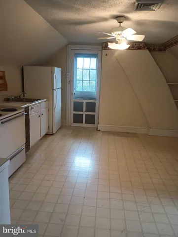 a view of a kitchen with microwave and refrigerator