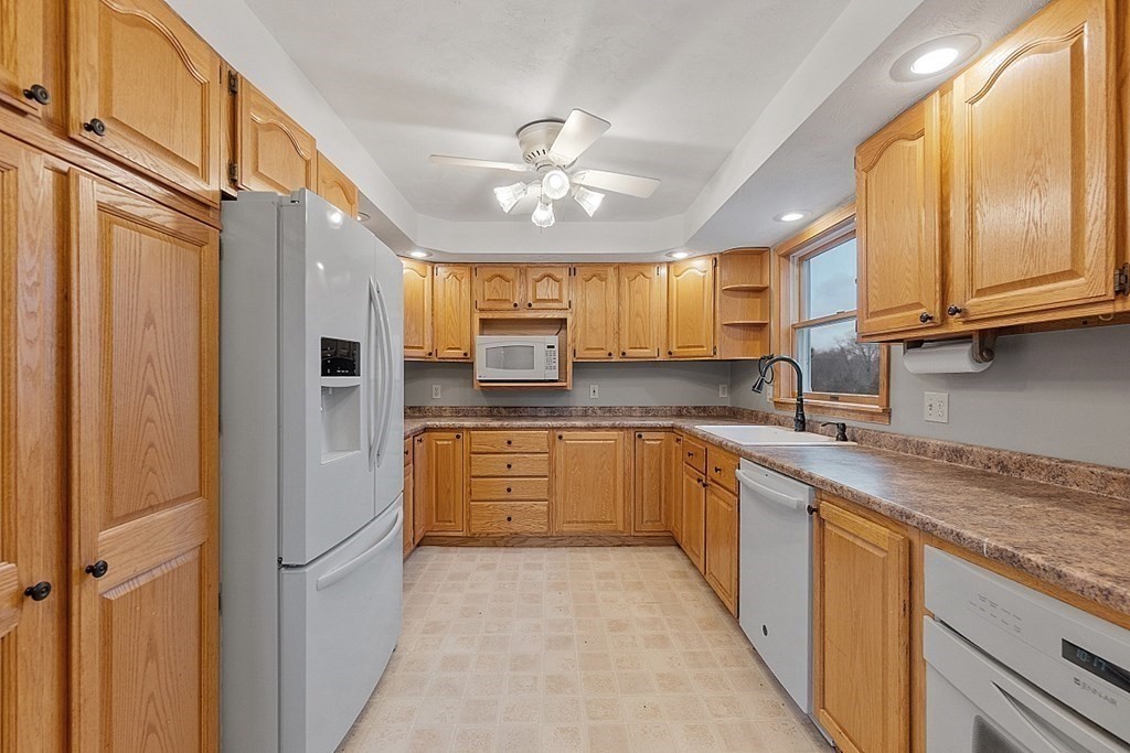 88 North End Road Townsend, MA 01469 - Photo 15 of 42 a kitchen with stainless steel appliances granite countertop a refrigerator a sink dishwasher and wooden cabinets with wooden floor