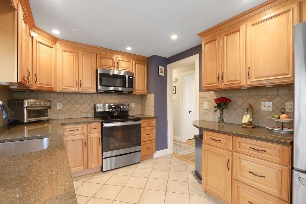51 Forest Street Reading, MA 01867 - Photo 3 of 22 a kitchen with stainless steel appliances granite countertop a stove a sink and a refrigerator