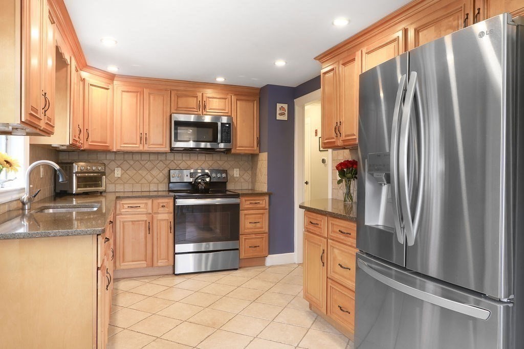 51 Forest Street Reading, MA 01867 - Photo 4 of 22 a kitchen with stainless steel appliances granite countertop a refrigerator and a sink