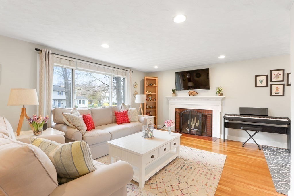 51 Forest Street Reading, MA 01867 - Photo 6 of 22 a living room with furniture a flat screen tv and a fireplace
