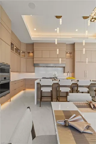 a living room with furniture a flat screen tv and kitchen view