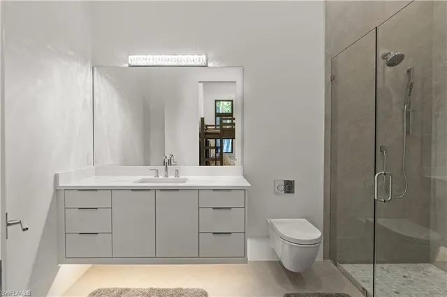 a bathroom with a granite countertop sink a toilet and shower