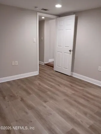 an empty room with wooden floor and cabinet