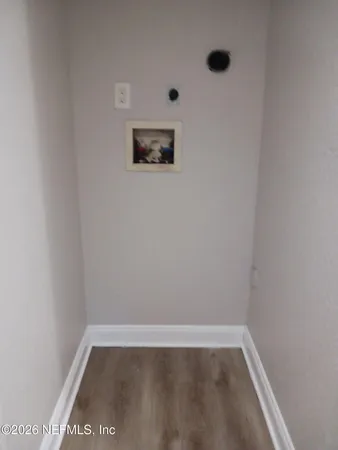 a view of a small space with wooden floor and a window