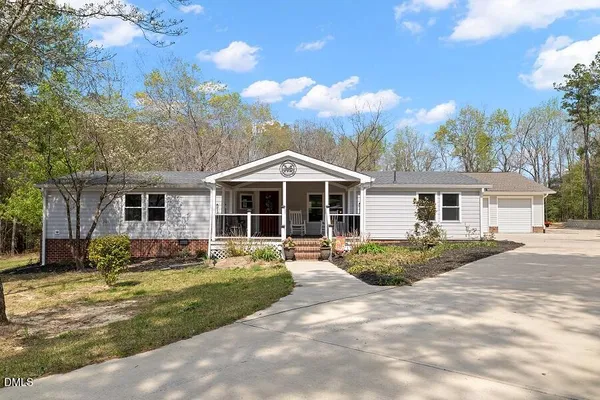 a front view of a house with a yard and trees