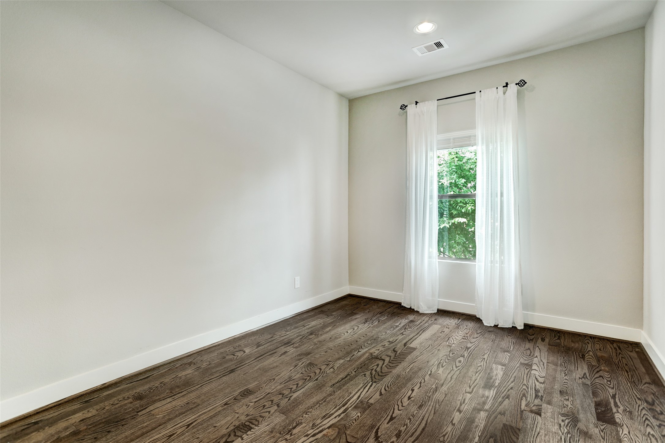 1309 Laird Street, Unit A Houston, TX 77008 - Photo 17 of 22 a view of an empty room with wooden floor and a window