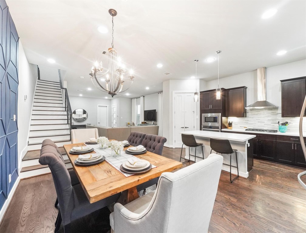 1309 Laird Street, Unit A Houston, TX 77008 - Photo 7 of 22 a dining room with wooden floor a chandelier a glass table and chairs