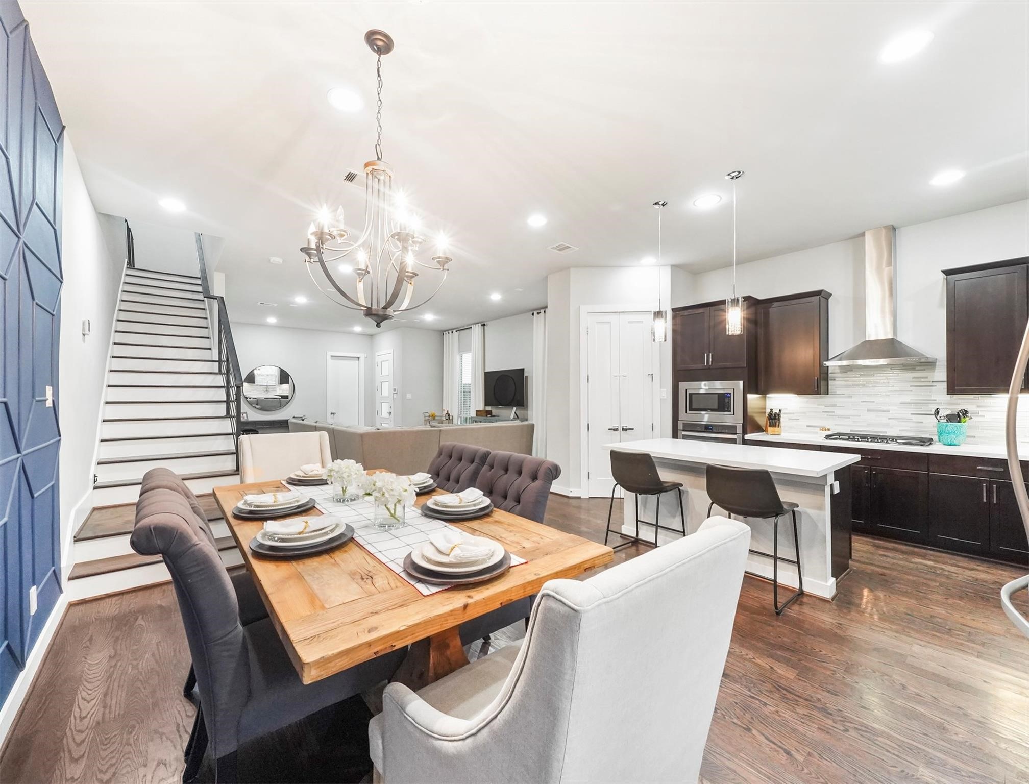 1309 Laird Street, Unit A Houston, TX 77008 - Photo 7 of 22 a dining room with wooden floor a chandelier a glass table and chairs