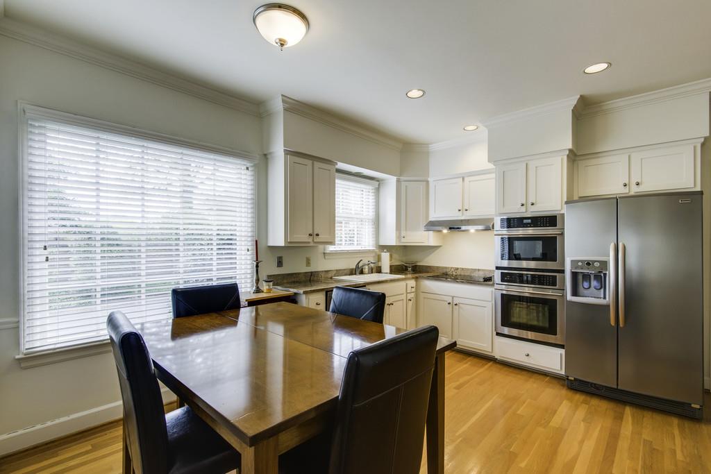 110 Prospect Hill Nashville, TN 37205 - Photo 9 of 23 a kitchen with stainless steel appliances granite countertop a stove top oven a sink dishwasher a dining table and chairs with wooden floor