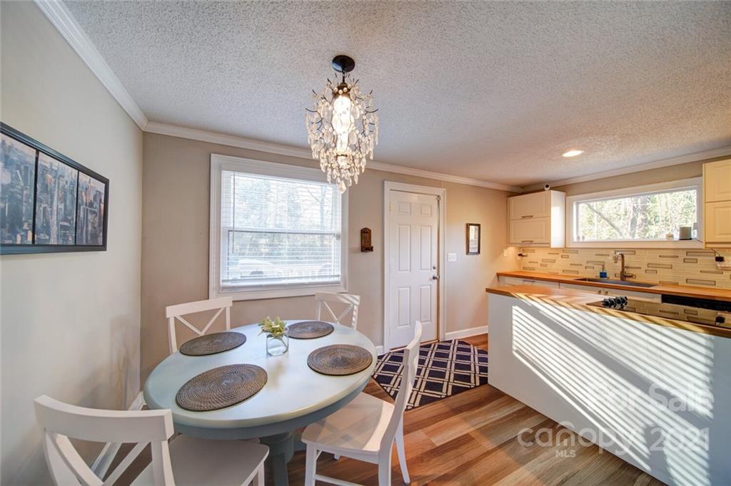 1032 Ravendale Drive Charlotte, NC 28216 - Photo 7 of 20 a kitchen with stainless steel appliances a dining table and chairs in it