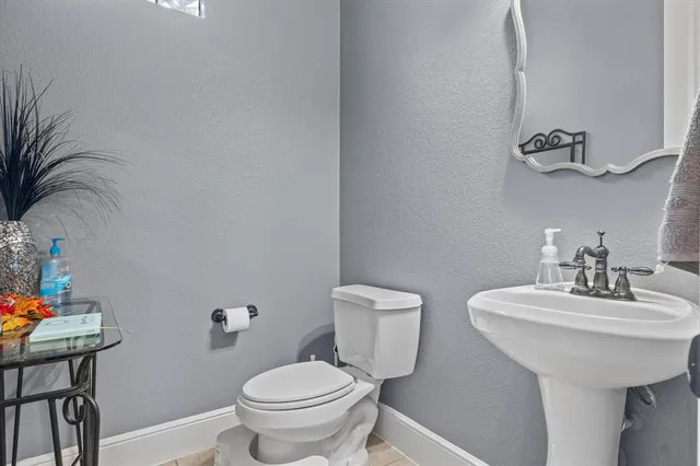 a bathroom with a sink toilet and a mirror