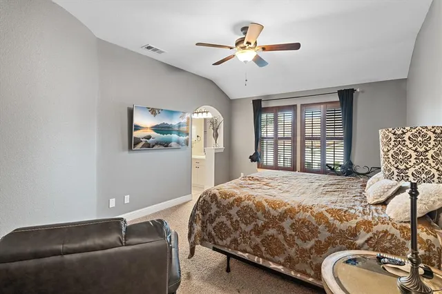 a bedroom with a bed dresser and wooden floor