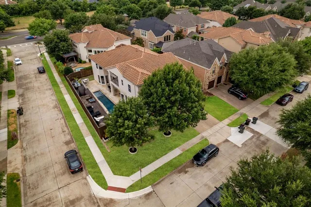 an aerial view of a residential houses with outdoor space and street view