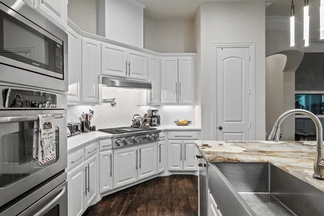 a kitchen with cabinets appliances and a sink
