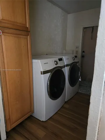a utility room with wooden floor washer and dryer