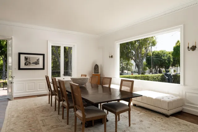a dining room with furniture and a large window
