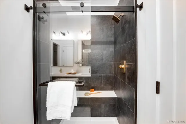 a bathroom with a shower sink and mirror