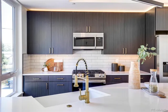 a kitchen with stainless steel appliances a stove a microwave a sink and cabinets