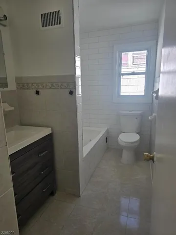 a bathroom with a sink a toilet and a window