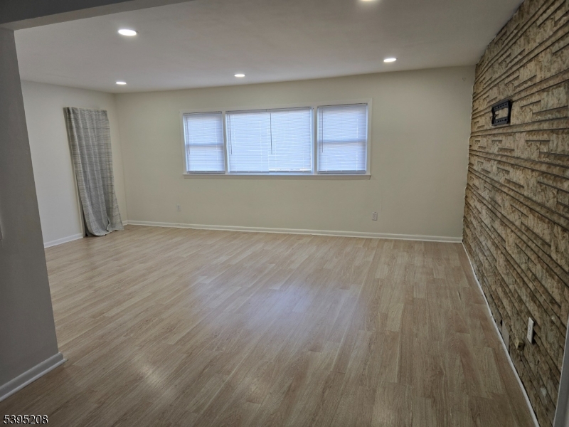 67 Lindsley Avenue Irvington, NJ 07111 - Photo 5 of 12 an empty room with wooden floor and windows