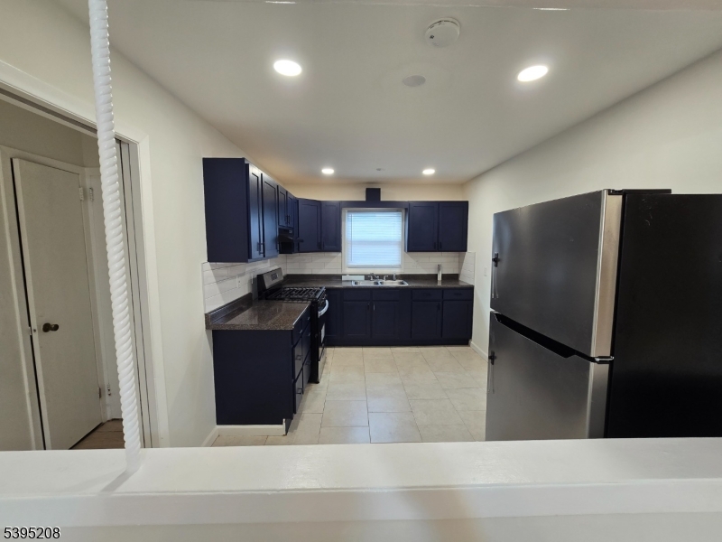 67 Lindsley Avenue Irvington, NJ 07111 - Photo 7 of 12 a kitchen with stainless steel appliances granite countertop a refrigerator a sink and a stove top oven