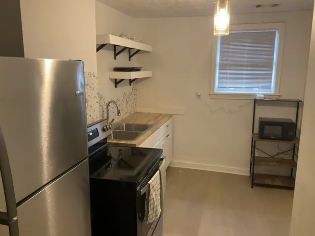 a kitchen with a refrigerator and a stove top oven