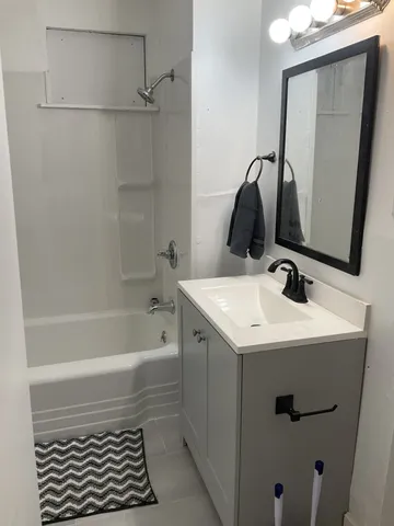 a bathroom with a sink a vanity and a bathtub